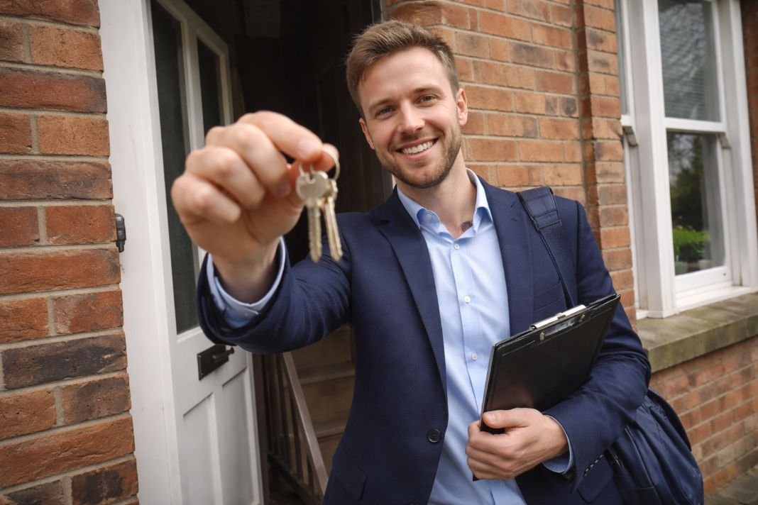An illustrative image of a London letting agent holding keys at the door of a terraced house