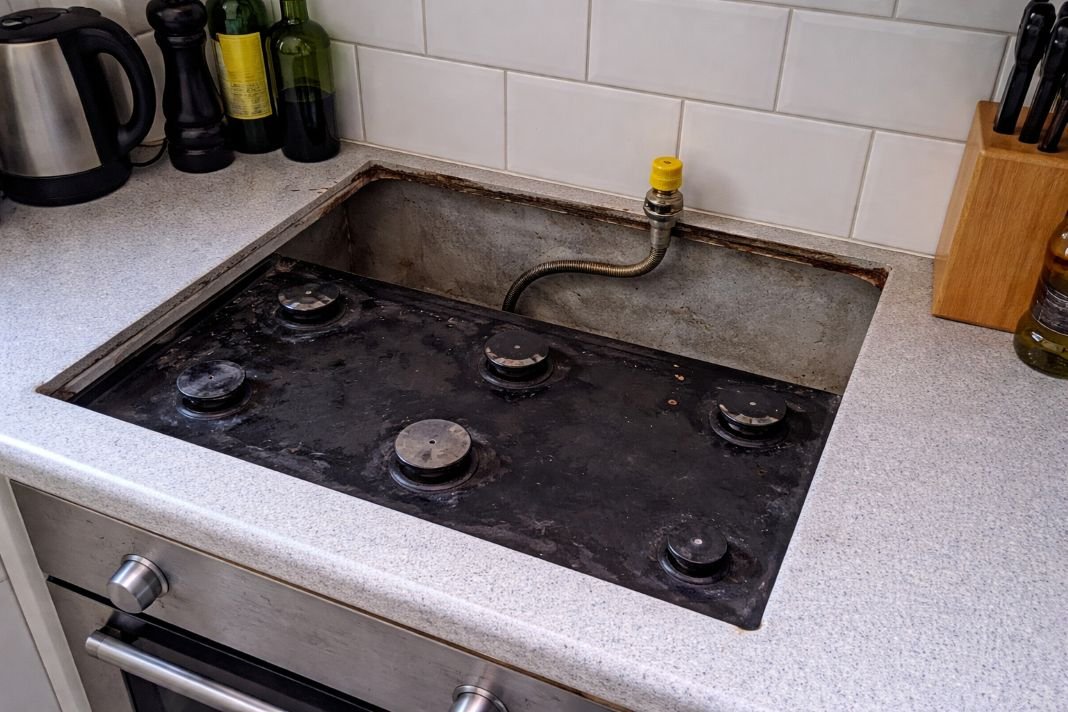 An illustrative image of a kitchen with the gas hob disconnected and a capped off gas pipe visible, showing a clear view of utility access