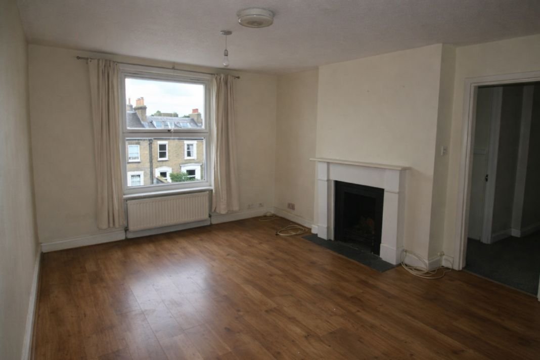 An illustrative image of a vacant living room in a London property ready for new tenants, with natural light and visible smoke alarm